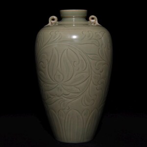 May include: A celadon-colored ceramic vase with a detailed floral pattern carved into its surface. The vase has a rounded body, a narrow neck, and two small loop handles. The design features a large lotus flower and other stylized leaves.