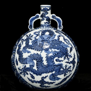 Könnte beinhalten: Eine weiß-blaue Keramikflasche mit einem Drachendesign. Die Flasche hat einen runden Körper, einen schmalen Hals und zwei Griffe. Der Drache ist in Blau auf weißem Hintergrund dargestellt. Die Flasche ist wahrscheinlich ein Dekorationsartikel.