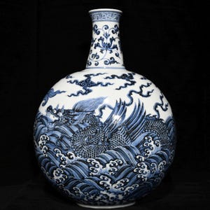 Op de afbeelding: Een blauwe en witte porseleinen vaas met een rond lichaam en een lange hals. De vaas is versierd met een draak en golven in een traditionele Chinese stijl.