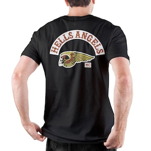 May include: Black t-shirt with the "Hells Angels" logo on the back. The logo features a winged skull and the letters "MC". The words "HELLS ANGELS" are arched above the logo in white and brown.
