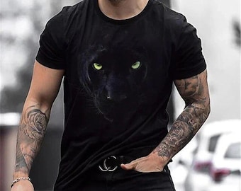 May include: Black crew neck t-shirt featuring a panther face with glowing green eyes. The graphic tee is made of a soft material and is suitable for casual wear. The shirt is a classic fit.