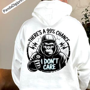 Könnte beinhalten: Weißer Kapuzenpullover mit einem schwarz-weißen Grafik eines Gorillas, der eine Kappe trägt und eine Blume hält. Der Text auf dem Kapuzenpullover lautet "THERE'S A 99% CHANCE I DON'T CARE". Der Kapuzenpullover hat eine Kapuze mit Kordelzug und lange Ärmel.