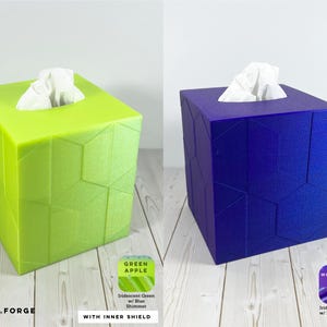 Pu&ograve; includere: Due copri scatole per fazzoletti quadrati con una texture geometrica sfaccettata. Uno &egrave; verde lime brillante etichettato Green Apple, l'altro &egrave; viola intenso etichettato Witchcraft Purple. Entrambi presentano una finitura iridescente e riflessi blu.
