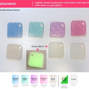 May include: A collection of seven square translucent material swatches with rounded corners and a single hole. Colors include blue, teal, purple, pink, gold, and clear, with glitter accents. One swatch is labeled as having a glow effect in green.