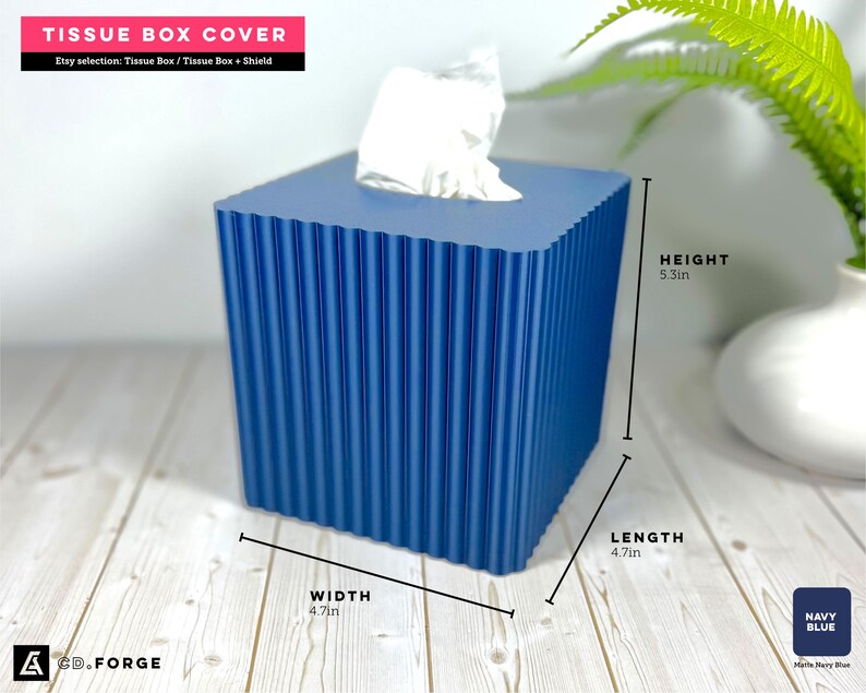 May include: A navy blue square tissue box cover with a vertical ribbed texture. The box measures 5.3 inches in height, 4.7 inches in width, and 4.7 inches in length. A white tissue is visible protruding from the top opening of the container.