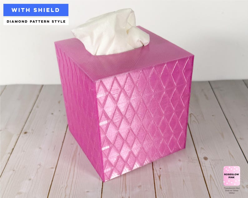 Pu&ograve; includere: Un copriscatola per fazzoletti quadrato di colore rosa vivace con un motivo a rombi in rilievo. La scatola presenta un'apertura superiore da cui fuoriescono fazzoletti bianchi. Il testo sull'immagine riporta WITH SHIELD e DIAMOND PATTERN STYLE.