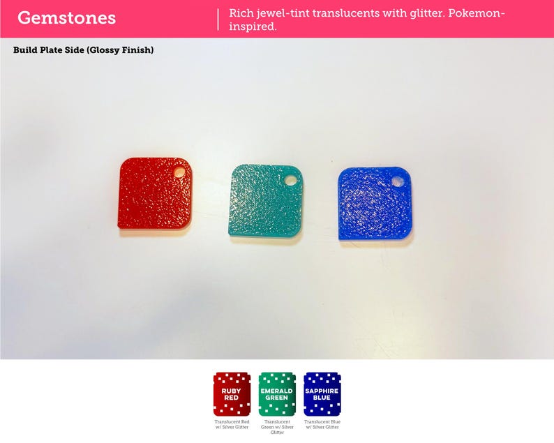 May include: Three square-shaped plastic tiles in red, green, and blue, each featuring a textured surface with silver glitter and a small circular hole in the top right corner. Text on the image includes Gemstones, Build Plate Side, Ruby Red, Emerald Green, and Sapphire Blue.