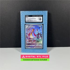 May include: A graded Pokémon card in a blue case. The card features a colorful illustration of a Milotic. The case has a CGC label with details and a grade of 10. Below the case is a green and pink banner that reads "DIGITAL STL FILE Commercial license included."