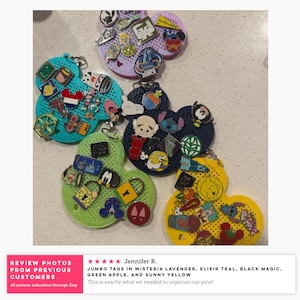 May include: Five Mickey Mouse-shaped pin display boards in wisteria lavender, elixir teal, black magic, green apple, and sunny yellow. Each board features a perforated surface covered with various colorful enamel pins, including character designs.
