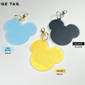 May include: Three large mouse-shaped tags with perforated surfaces. One is ice blue with a gold clasp, one is yellow with a gold clasp, and one is black with a silver clasp. The text LARGE TAG, ICE BLUE GOLD, BLACK SILVER, and GOLD GOLD is visible.