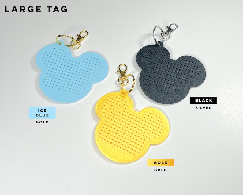 May include: Three large mouse-shaped tags with perforated surfaces. One is ice blue with a gold clasp, one is yellow with a gold clasp, and one is black with a silver clasp. The text LARGE TAG, ICE BLUE GOLD, BLACK SILVER, and GOLD GOLD is visible.
