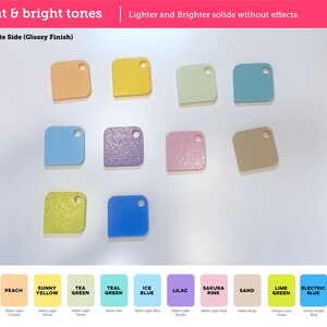 May include: A collection of ten square-shaped plastic swatches with rounded corners and a single hole in the top right corner. The colors include peach, yellow, light green, teal, blue, purple, pink, sand, lime green, and bright blue.