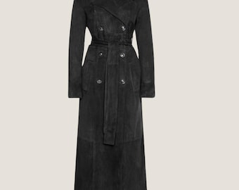 May include: A long, black trench coat with a double-breasted design. The coat features a belt at the waist and buttons down the front. The coat is made of a soft, suede-like material.