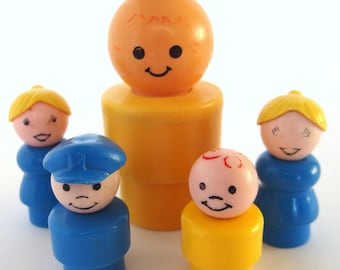 May include: A collection of vintage Fisher-Price Little People figures. The figures are in various colours, including orange, blue, yellow, and pink. Each figure has a smiling face and simple design.