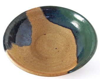 May include: A ceramic bowl with a brown interior and a blue and green glaze on the exterior.