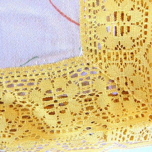 May include: Yellow crochet lace trim with a delicate floral pattern. The lace is made of a fine thread and has a soft, airy feel.