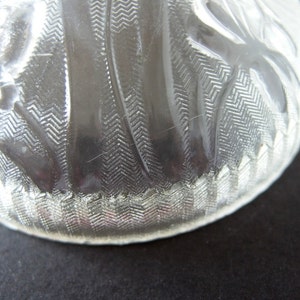 May include: A clear glass bowl with a textured, wavy design. The bowl has a scalloped edge and is made of clear glass.