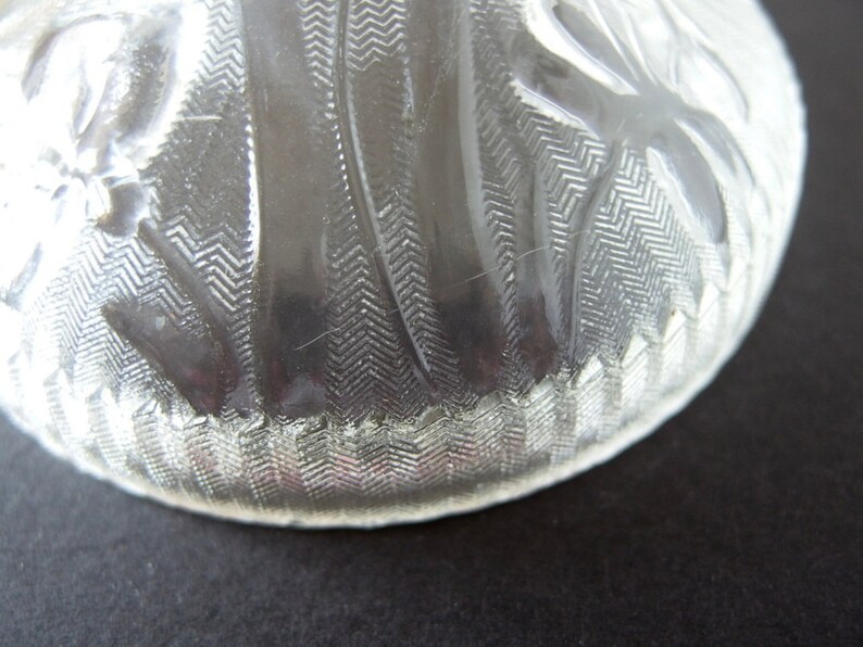 May include: A clear glass bowl with a textured, wavy design. The bowl has a scalloped edge and is made of clear glass.