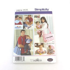 May include: Simplicity sewing pattern 2924, featuring images of babies and parents with baby accessories. The pattern includes a diaper bag, bibs, and other items. The pattern is one size and includes the text "Sign up for our free newsletter today at simplicity.com."