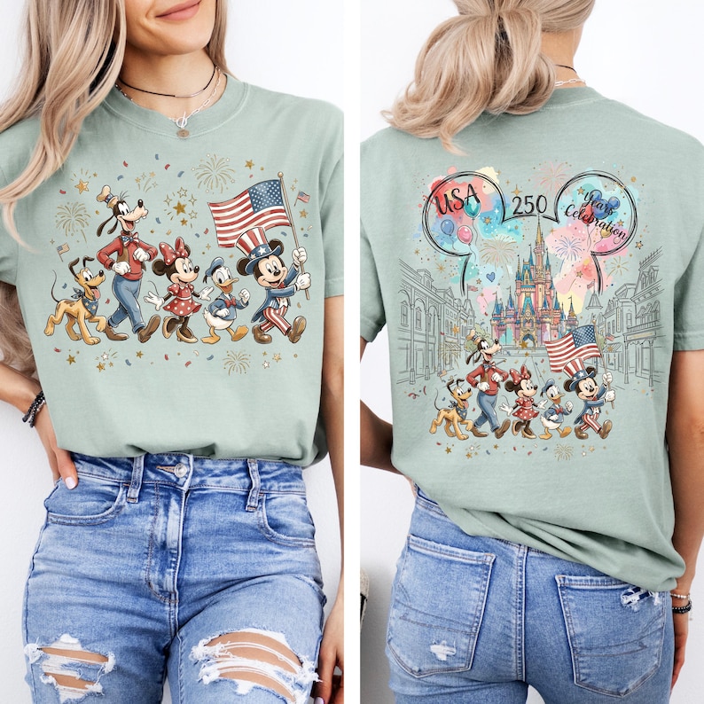 Peut inclure: Un t-shirt vert sauge avec une illustration de Mickey, Minnie, Donald, Dingo et Pluto en tenue patriotique tenant un drapeau am&eacute;ricain. Le dos pr&eacute;sente un ch&acirc;teau, des feux d'artifice et le texte USA 250 Years Celebration imprim&eacute; en couleur.
