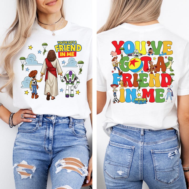 Op de afbeelding: Wit T-shirt met de tekst "YOU'VE GOT A FRIEND IN ME" op de voor- en achterkant. De voorkant heeft stripfiguren en de achterkant een kleurrijk ontwerp met meer figuren. Het shirt is gemaakt van zacht materiaal.