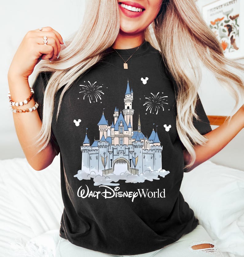 May include: Black t-shirt with a detailed illustration of Cinderella's castle, blue turrets, fireworks, and the text "Walt Disney World." The design includes white Mickey Mouse silhouettes.