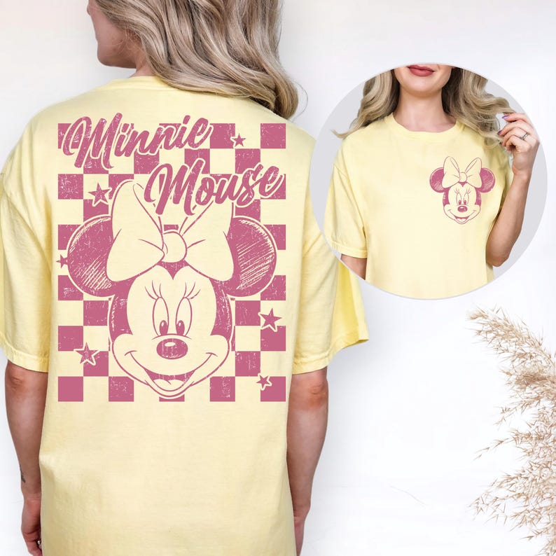 Puede incluir: Camiseta amarilla clara con un gr&aacute;fico de Minnie Mouse. La parte trasera presenta un gran dise&ntilde;o de Minnie Mouse sobre un fondo a cuadros rosa, con las palabras "Minnie Mouse". La parte delantera tiene un gr&aacute;fico de Minnie Mouse m&aacute;s peque&ntilde;o.