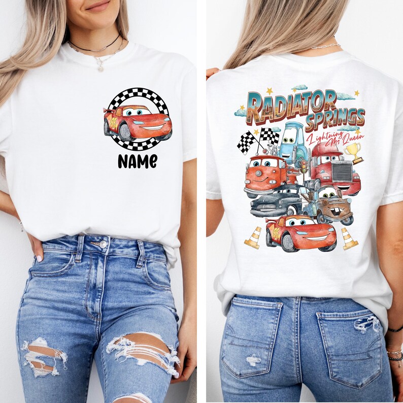 May include: White t-shirt featuring a cartoon car design with the text "NAME" on the front. The back of the shirt displays a colorful graphic of various cartoon cars with the text "Radiator Springs Lightning McQueen".