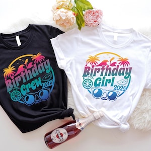 May include: Two t-shirts, one black and one white, with a colorful graphic design. The design includes the words "Birthday Crew 2025" and "Birthday Girl 2025" with sunglasses, palm trees, and a beach theme.