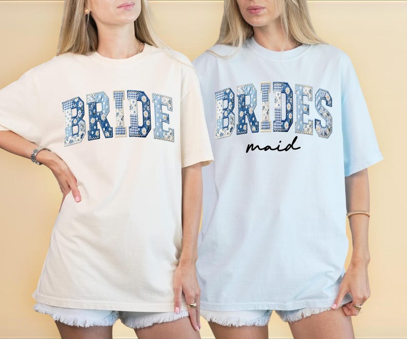 Puede incluir: Dos camisetas, una crema y otra azul claro, con texto. La camiseta crema dice "BRIDE" en letras de patchwork azules. La camiseta azul claro dice "BRIDES" encima de "maid" en escritura negra, con letras de patchwork azules.
