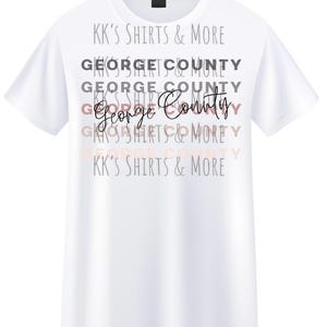 May include: White t-shirt with the text "George County" in a cursive font, layered over the words "George County" and "KK's Shirts & More" in various fonts and colors. The shirt has short sleeves.