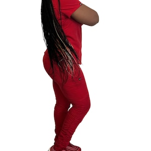 May include: A red short-sleeved top and matching pants set. The pants have a ruched design at the ankles. The outfit is made of a soft material and is suitable for casual wear.