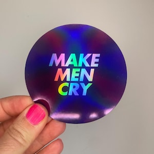 Könnte beinhalten: Ein runder, holografischer Aufkleber mit dem Text "MAKE MEN CRY" in Regenbogenfarben. Der Aufkleber hat einen dunkelblauen und violetten Hintergrund mit einem glänzenden, irisierenden Finish.