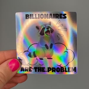 May include: Holographic sticker featuring a raccoon on a cloud, with the text "BILLIONAIRES ARE THE PROBLEM." The raccoon is depicted with an open mouth and radiating lines. The sticker has a rainbow sheen.