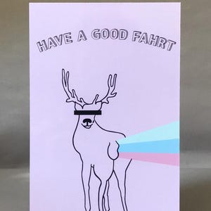Op de afbeelding: Een lichtpaarse wenskaart met een zwarte lijntekening van een hert met een zwart rechthoek over zijn ogen. De kaart leest "HAVE A GOOD FAHRT" in een gebogen lettertype. Het hert heeft een kleurrijk, gestreept ontwerp dat uit zijn achterste komt.
