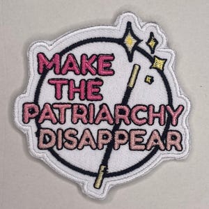 Könnte beinhalten: Gestickter Aufnäher mit dem Schriftzug "MAKE THE PATRIARCHY DISAPPEAR" in rosa Buchstaben. Der Aufnäher zeigt einen schwarzen Zauberstab, Sterne und einen weißen Rand.