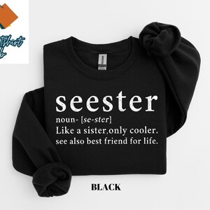 May include: Black sweatshirt with the text "seester" defined as "Like a sister, only cooler. See also best friend for life."