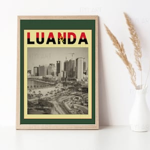 May include: Framed print featuring a sepia-toned cityscape of Luanda, Angola, with the city's name in bold letters above. The print has a green border and a light wood frame, creating a vintage aesthetic.