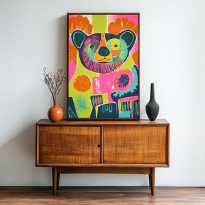 Op de afbeelding: Een kleurrijk abstract schilderij van een beer met felle roze, groene, blauwe en oranje kleuren. De beer is omringd door bloemen en geometrische vormen.