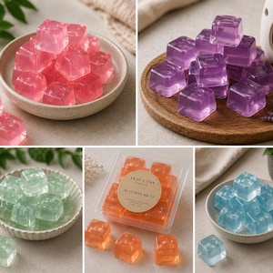 Op de afbeelding: Een collectie doorschijnende, kubusvormige gelei-waxmelts in roze, paars, groen, oranje en blauw. De oranje melts zitten in een doorzichtige plastic verpakking met een rond etiket met de tekst SAGE + OAK JELLY WAX MELTS.