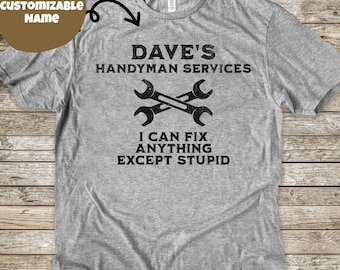 May include: A gray t-shirt with the text "DAVE'S HANDYMAN SERVICES" and the crossed wrenches graphic. Below the graphic, the text reads "I CAN FIX ANYTHING EXCEPT STUPID". The shirt is a crew neck.