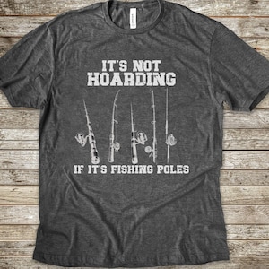 Op de afbeelding: Een donkergrijs gem&ecirc;leerd T-shirt met korte mouwen en een witte afbeelding van vijf hengels. De in het wit gedrukte tekst luidt: IT'S NOT HOARDING IF IT'S FISHING POLES. Het shirt heeft een ronde hals en een standaard pasvorm.