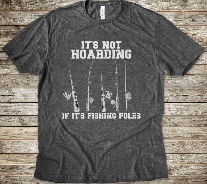 Op de afbeelding: Een donkergrijs gem&ecirc;leerd T-shirt met korte mouwen en een witte afbeelding van vijf hengels. De in het wit gedrukte tekst luidt: IT'S NOT HOARDING IF IT'S FISHING POLES. Het shirt heeft een ronde hals en een standaard pasvorm.