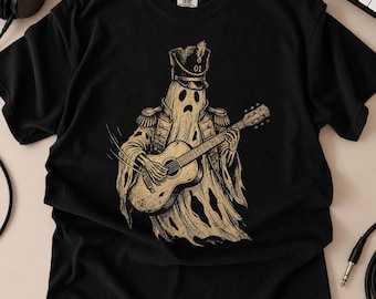 May include: A black short-sleeve t-shirt featuring a beige graphic print of a ghost dressed in a military-style uniform with a hat labeled 01, playing an acoustic guitar. The design has a distressed, etched appearance with visible line work.