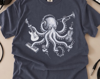 May include: A dark blue t-shirt featuring a white graphic print of an octopus wearing headphones and holding various musical instruments including an electric guitar, a trumpet, a violin, a keyboard, a microphone, a tambourine, and drumsticks.