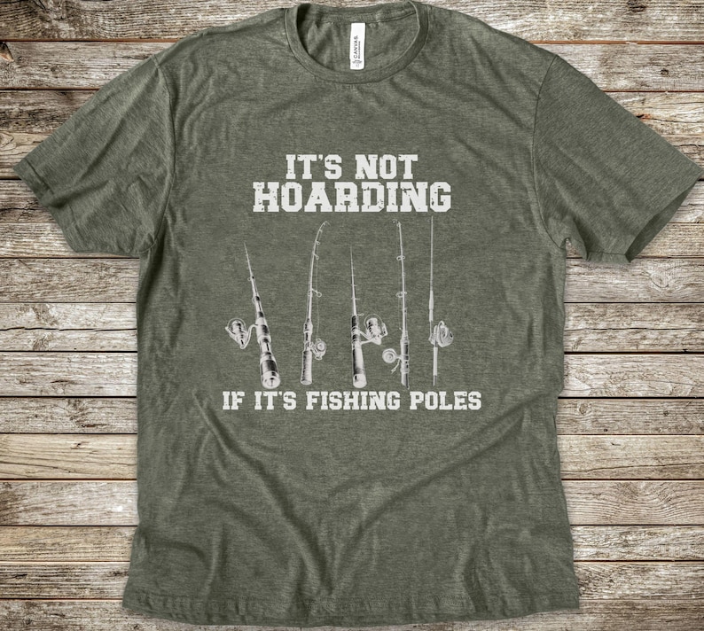 Op de afbeelding: Een olijfgroen gem&ecirc;leerd T-shirt met korte mouwen en een witte afbeelding van vijf hengels. De in het wit gedrukte tekst luidt: IT'S NOT HOARDING IF IT'S FISHING POLES. Het T-shirt heeft een ronde hals en een standaard pasvorm.