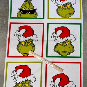 May include: Fabric panel featuring the Grinch in various expressions, wearing a Santa hat or sunglasses, set against a white background with green and red borders. The words "MERRY GRINCHMAS!" are printed at the top. The bottom has Grinch-themed ornaments.