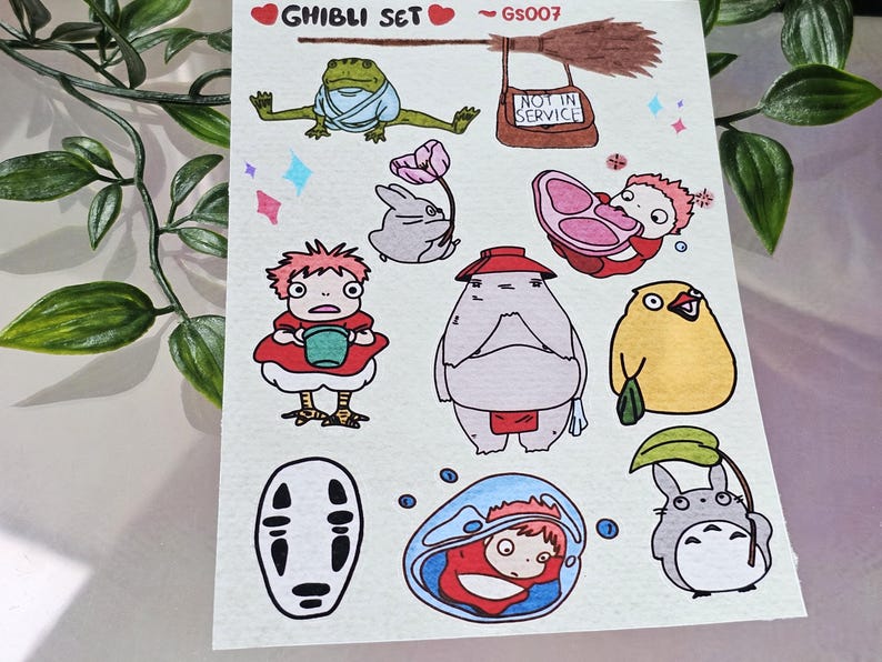 K&ouml;nnte beinhalten: Eine Sammlung von Aufklebern zum Thema Ghibli mit Charakteren aus verschiedenen Zeichentrickfilmen. Die Aufkleber zeigen einen Frosch, ein Kaninchen, einen Totoro und andere bekannte Figuren. Der Text "Ghibli Set" und "GS007" ist ebenfalls sichtbar.