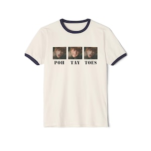 Può includere: T-shirt color crema con bordatura blu navy. La maglietta presenta tre immagini rettangolari di una persona con il testo "POH TAY TOES" sotto le immagini. La maglietta è uno stile casual.