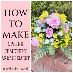 May include: How to Make Spring Cemetery Arrangement - Digital Video Tutorial. A floral arrangement in a green vase with pink and yellow flowers, set on a brick wall.